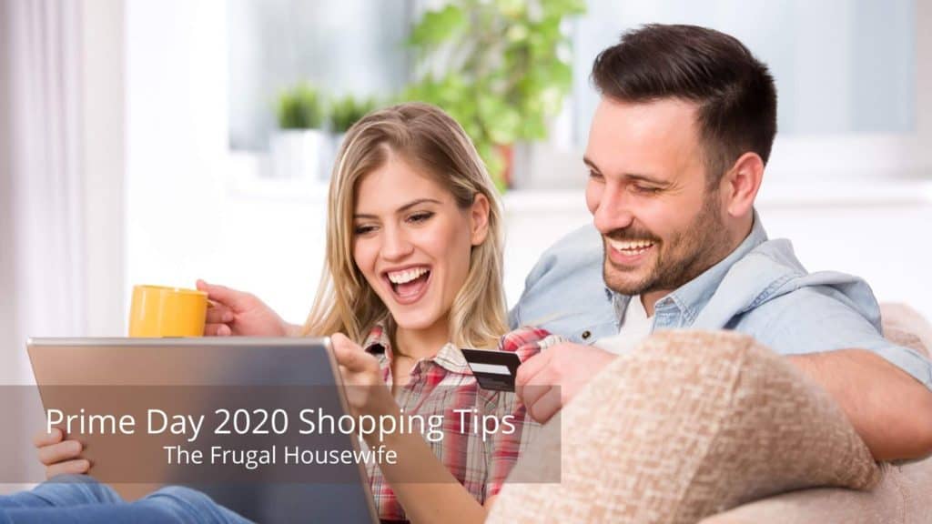 Couple on couch using laptop to shop.   Man is holding a credit card in his hand.  