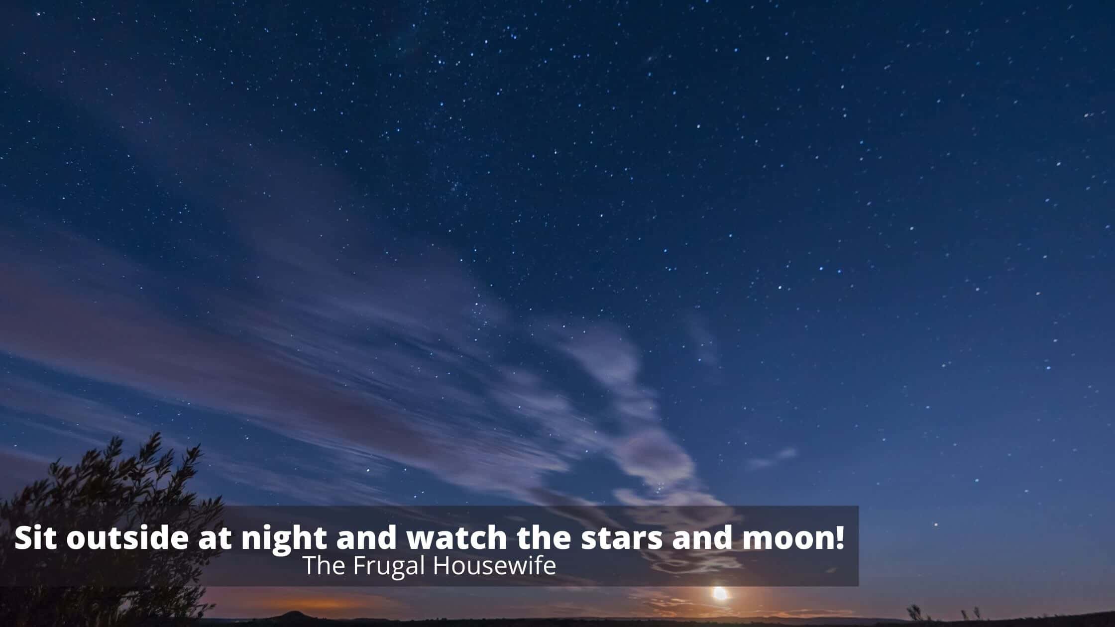 Night sky with stars and moon and some floating clouds.